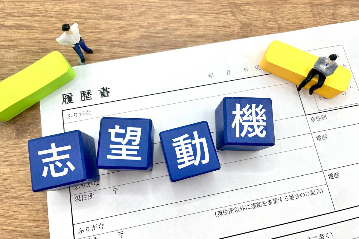 履歴書の上に並んだ『志望動機』の文字ブロック。介護職の応募でよくあるNG例と改善例を示すイメージ